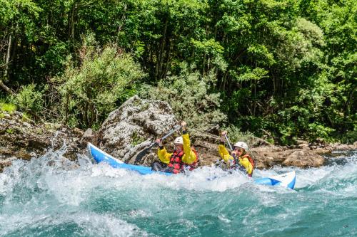 two people in a blue kayak on a river at GRAB ethno village and camp in Šćepan-Polje