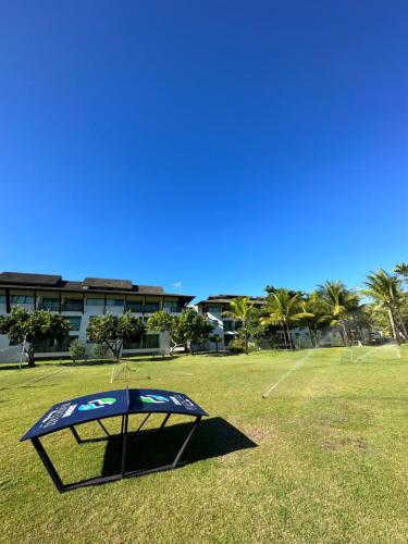 a golf cage in a field with a building in the background at Beach class muro alto in Porto De Galinhas