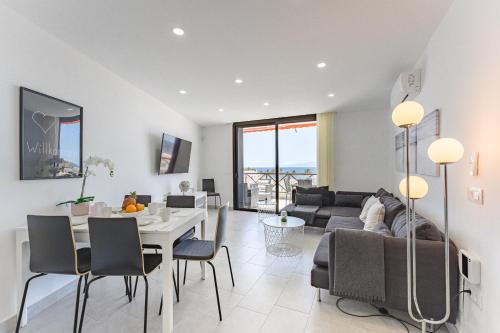 a living room with a couch and a table and chairs at Ferienwohnung Tower Penthouse Parque Santiago I in Playa de las Americas