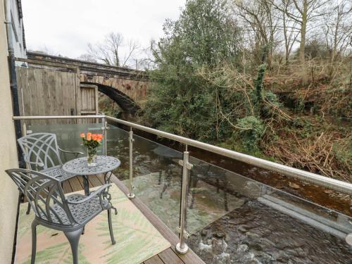 a balcony with a table and chairs and a bridge at Riverbank View in Whitby