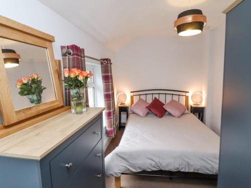 a bedroom with a bed with a vase of flowers at Riverbank View in Whitby