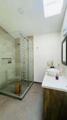 a bathroom with a glass shower and a sink at Hermoso Loft en Valquirico, Lofts Frontana. in Tlaxcala de Xicohténcatl