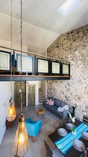 a living room with a couch and a stone wall at Hermoso Loft en Valquirico, Lofts Frontana. in Tlaxcala de Xicohténcatl