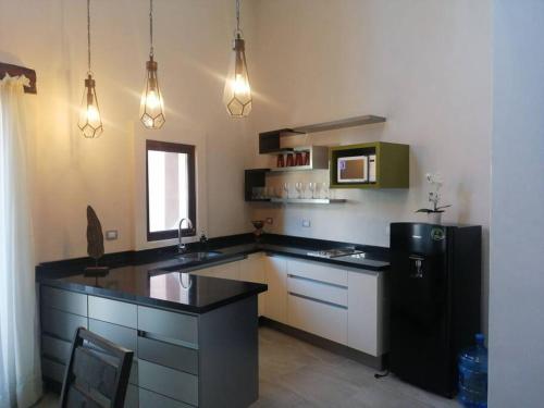 a kitchen with a black counter and a refrigerator at Hermoso Loft en Valquirico, Lofts Frontana. in Tlaxcala de Xicohténcatl