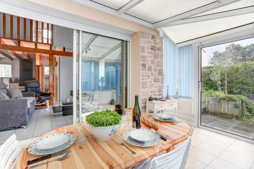 Il comprend une cuisine et un salon avec une table en bois. dans l'établissement Ker Heora - Maison avec piscine partagée, à Erquy