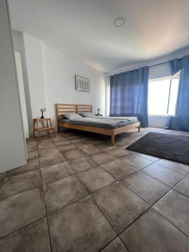 1 dormitorio con 1 cama y suelo de baldosa en San Agustin2, quiet apartment close to the beach, en San Bartolomé