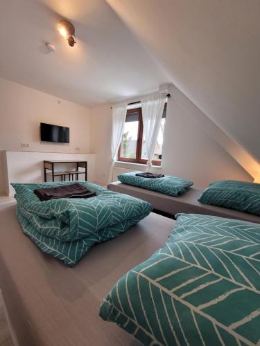 a bedroom with two beds and a tv on the wall at Monteurzimmer Noack in Uetze