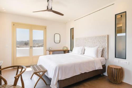 a bedroom with a large white bed and a window at Casa del Lupo in Platis Gialos