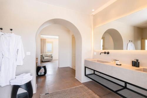 a white bathroom with a sink and a mirror at Casa del Lupo in Platis Yialos Mykonos