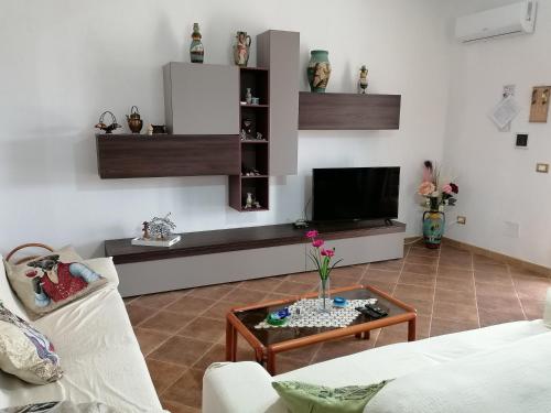 uma sala de estar com uma televisão e uma mesa de centro em Casa Waida em Marinella di Selinunte