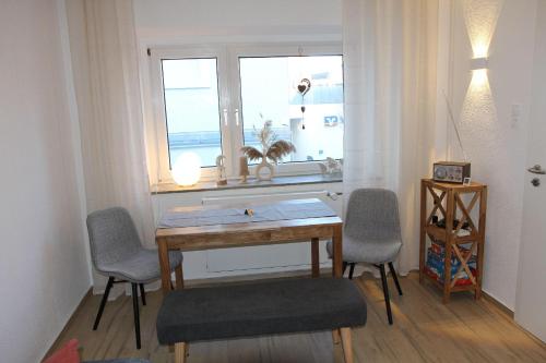 eine Küche mit einem Tisch und Stühlen sowie einem Fenster in der Unterkunft Ferienwohnung Hahnenstraße in Steinfurt
