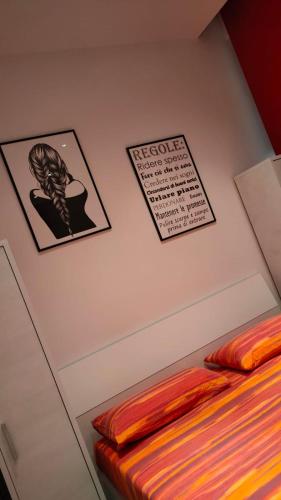 a bedroom with three pictures on the wall and a bed at VIGEVANO LA STAZIONE in Vigevano