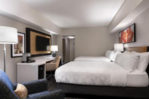 a hotel room with a bed and a desk and a chair at Holiday Inn - Chicago Dwtn - The Mart by IHG in Chicago