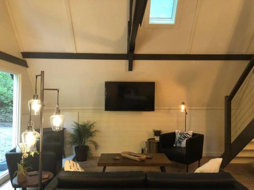 salon z kanapą i telewizorem na ścianie w obiekcie Newly renovated A-frame 5 Min walk to main street w mieście Highlands