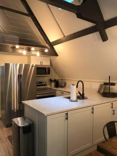 a kitchen with white cabinets and a stainless steel refrigerator at Newly renovated A-frame 5 Min walk to main street in Highlands