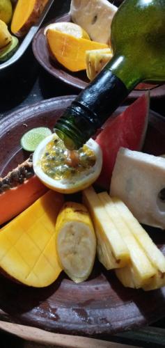 a plate of fruit and vegetables with a bottle of sauce at Cinnabar Resort in Tangalle