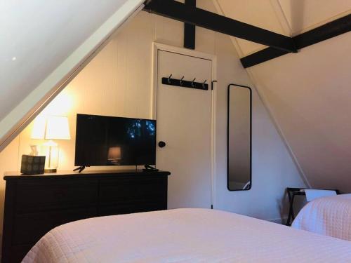 a bedroom with a bed and a tv and a window at Newly renovated A-frame 5 Min walk to main street in Highlands