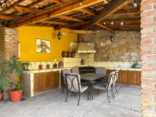 a patio with a table and chairs in a kitchen at Casa Amarilla in Guanajuato