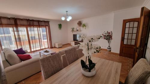 een woonkamer met een tafel met een vaas met bloemen bij Caravel Building in Lagos