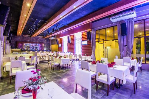 a dining room with white tables and white chairs at Ariana Hotel in Dipolog