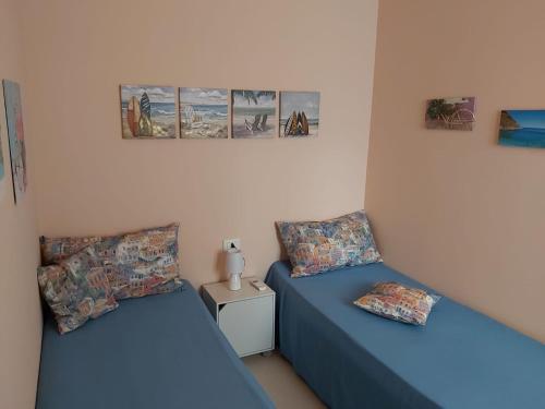 a room with two beds and a table at Casa Vacanze Villa Rosa Beach in Isola delle Femmine