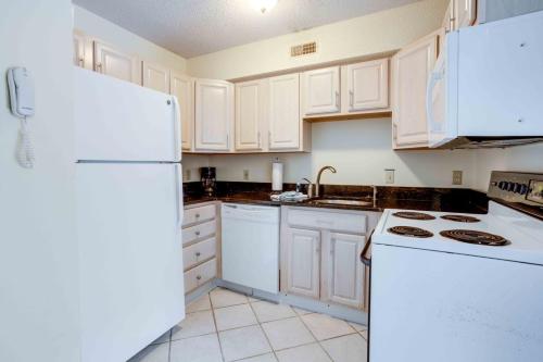 a kitchen with white appliances and a white refrigerator at Marylander Condominiums, 90 steps from the beach in Ocean City