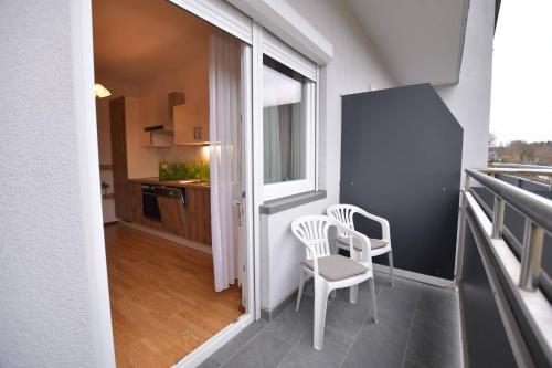 a balcony with two chairs and a table and a window at HOTEL Jerolitsch in Krumpendorf am Wörthersee