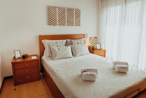 a bedroom with a bed with two towels on it at RACIA Lodges - Apartment in Viana do Castelo