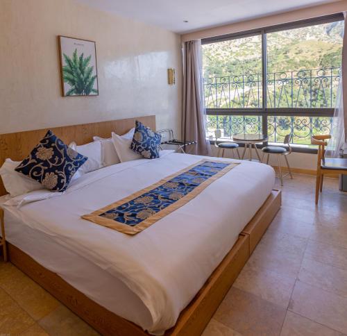 a bedroom with a large bed with a large window at VANCII Hotel in Chefchaouene