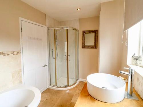 a bathroom with a shower and a tub and a sink at Hunters Lodge, with parking for one car in Lincoln