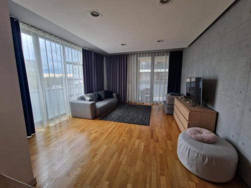 - un salon avec un canapé et une télévision dans l'établissement Anvers Apartament, à Bucarest