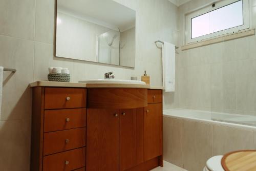 y baño con lavabo, bañera y espejo. en RACIA Lodges - Apartment, en Viana do Castelo