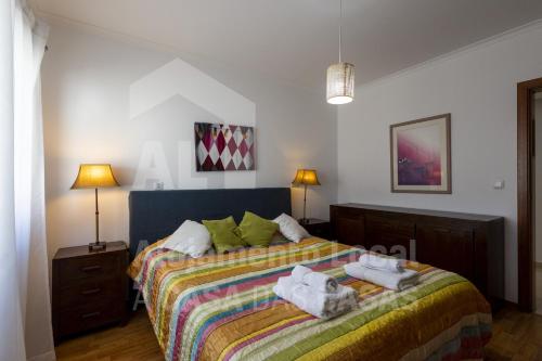 een slaapkamer met een bed met handdoeken erop bij Blue Beach by ACasaDasCasas in Ericeira