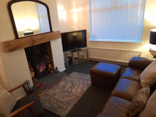 a living room with a couch and a fireplace at Fabulous terrace cottage in Blackpool