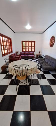 una stanza con tavolo e sedie su un pavimento a scacchi di Pousada Villa D' Garden a Ribeirão Preto
