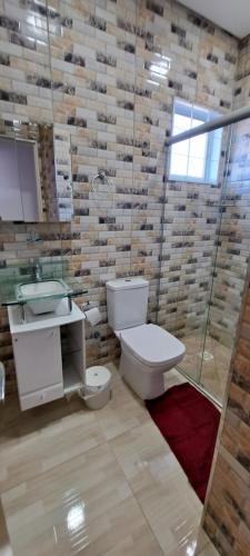 y baño con aseo, lavabo y ducha. en Pousada Villa D' Garden en Ribeirão Preto
