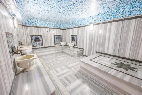 a bathroom with three toilets and a blue ceiling at selin otel spa belek in Belek