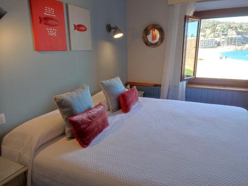 1 dormitorio con 1 cama con almohadas rojas y azules en Hotel Cap d'Or, en Tossa de Mar