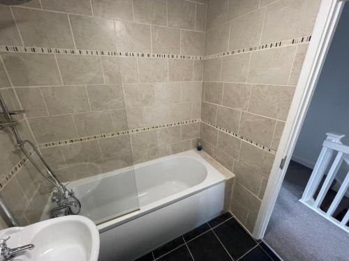 a bathroom with a bath tub and a sink at River View House St Neots - Navigation Wharf in Saint Neots