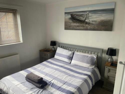 a bedroom with a bed and a picture of a boat at River View House St Neots - Navigation Wharf in Saint Neots