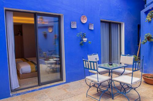 a blue room with a table and chairs and a bed at VANCII Hotel in Chefchaouene