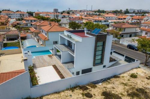 a white house with a view of a city at Villa Nazaré - Pool, BBQ and Boule/Petanque in Nazaré