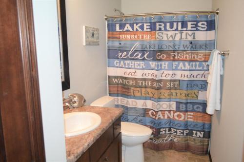 a bathroom with a toilet and a shower curtain at Bridges Bay Vacation Cabin 185 in Arnolds Park