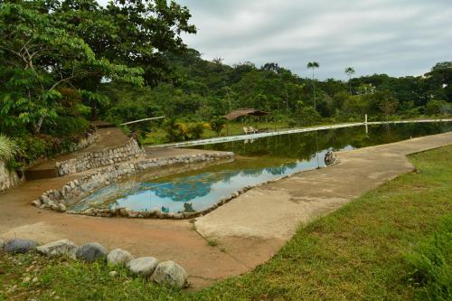 una pequeña piscina de agua junto a una carretera en Donde se Oculta el Sol en Villagarzón