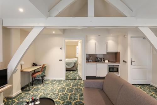 a living room with a couch and a kitchen at Boutique Hotel Jeroen in Den Bosch