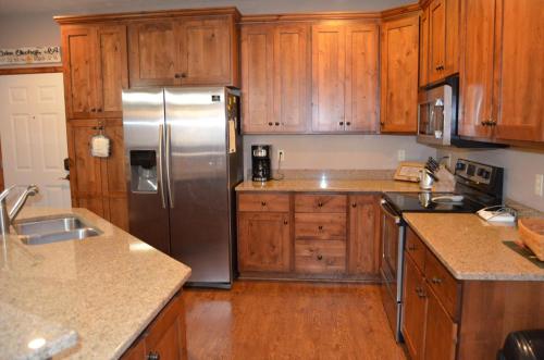 een keuken met houten kasten en een roestvrijstalen koelkast bij Bridges Bay Resort Coronado building 200 in Arnolds Park