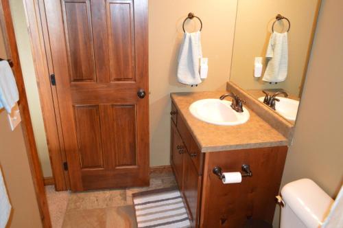 een badkamer met een wastafel en een houten deur bij Bridges Bay Vacation Cabin 13 in Arnolds Park