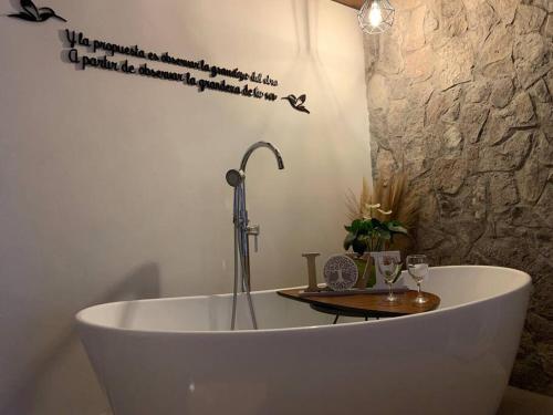 a bath tub with a faucet and two wine glasses at Hermoso departamento en Val’Quirico Loft Frontana in Tlaxcala de Xicohténcatl