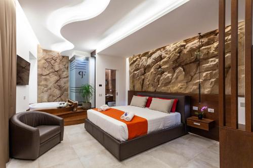 Palazzo Ferrucci Luxury Suites في كالياري: غرفة نوم بسرير كنج وكرسي