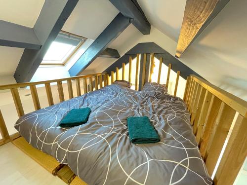 Un dormitorio con una cama con almohadas verdes. en Escapade Morétaine - Le Loft, en Moret-sur-Loing